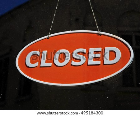 Distinctive Contrast: A Round Red and White 'Closed' Sign Against a Dark Background