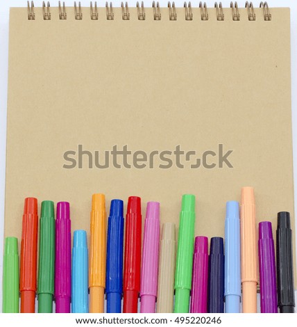 colored pen and blank notebook on a white background