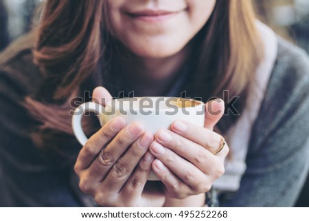 Closeup image of Asian woman drinking hot coffee with feeling good