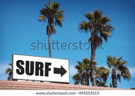 surf sign on building with palm trees                               