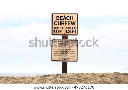 beach curfew sign on sand                              