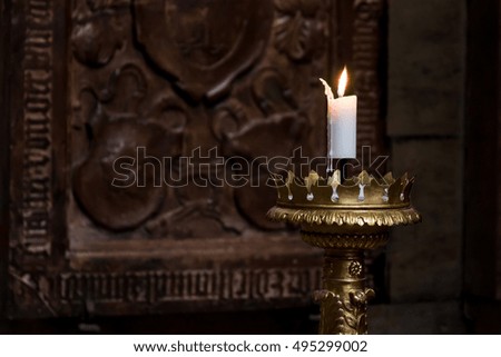 Burning candle on the vintage gold candlestick in St. Vitus Cathedral, Prague