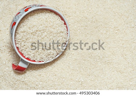 Textured background rice grains on the surface, and a Cup