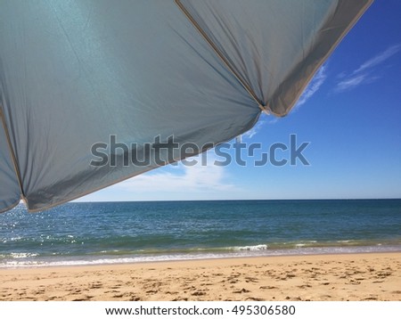 Sunny umbrella against blue sky outdoors background