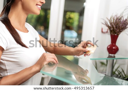 cheerful customer paying in a lobby of hair salon