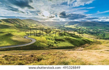 Serpentine Road Among Green Hills of Peak District National Park Royalty-Free Stock Photo #495328849