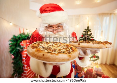 Pizza in the hands of Santa Claus at Christmas, happy new year close-up.