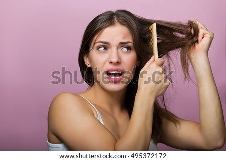 Woman brushing her hair with a wooden comb