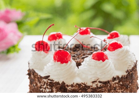 Black forest cake decorated with whipped cream and cherries