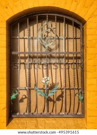 old window with grid and wrought iron flowers