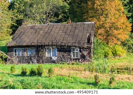 Abandoned wooden house at the pond