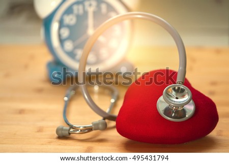 Stethoscope Heart medical care with blur time clock background 