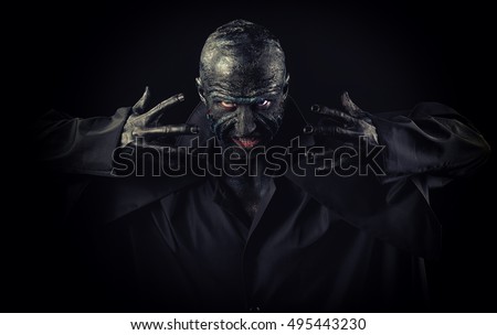 Studio portrait of a man in monster makeup, dark background
 Royalty-Free Stock Photo #495443230