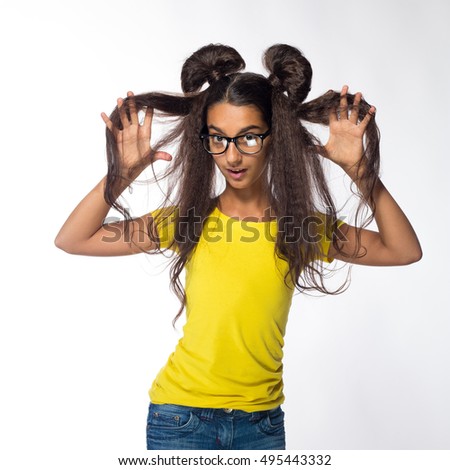 Emotional young brunette girl with long hair in yellow shirt with sunglasses on a white background