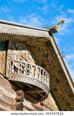 Wooden horse on the roof of traditional Russian cottage, painted Russian wooden architecture at the north of Russia