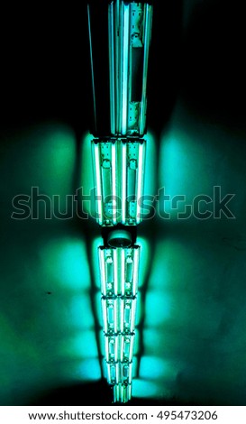 vertical long lamp against dark background, vertical lamps divided into sections with lights against dark background, high quality resolution, ceiling office lamp with light