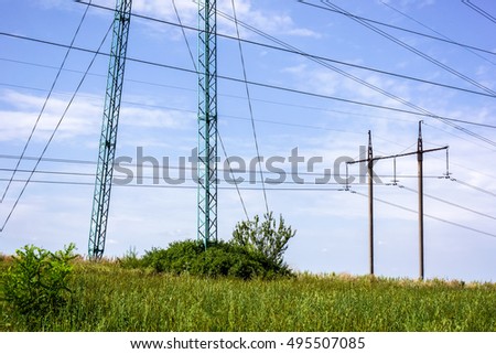 Summer landscape with green forest and power towers against blue sky with clouds on sunset