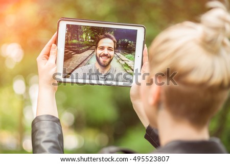 young couple in love chatting over a video call, by using a tablet. graded with a flare Royalty-Free Stock Photo #495523807