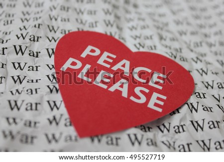 Paper red heart with the inscription "Peace Please". Paper background with the word "War".