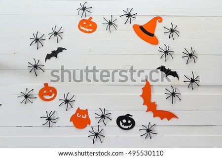 Halloween background with frame of paper pumpkins, bat and decorative spiders. Space for text.