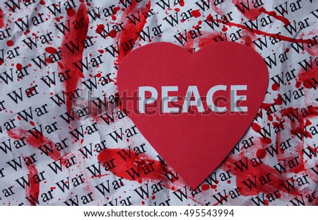 Paper red heart with the inscription "Peace" on paper background with the word "War".