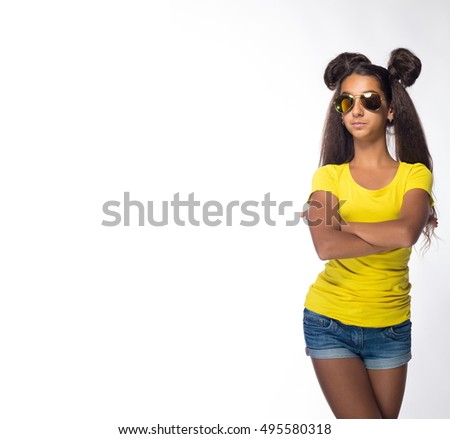Emotional young brunette girl with long hair in yellow shirt and sunglasses on a white background