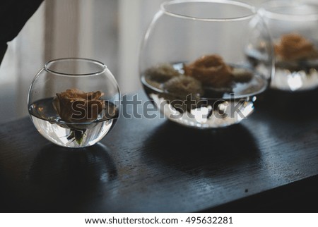 Darkened picture of glass bowls and rose buds floating in them