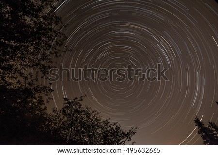 Long startrails with centre of polaris star, tree silhouette, end of summer, Slovakia
