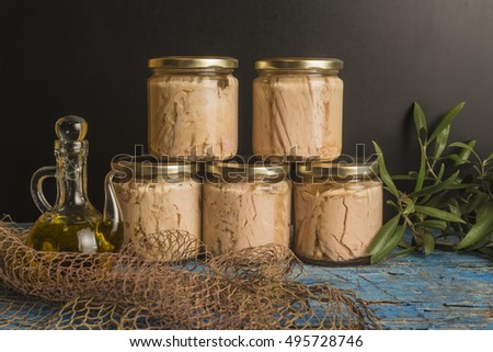 Tuna canned in jars with olive oil on blue rustic table, albacore Cantabrian sea Royalty-Free Stock Photo #495728746