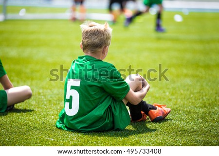 Young caucasian european soccer player watching football game