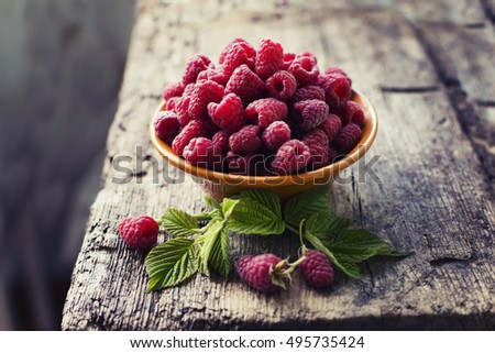 Fresh Ripe sweet raspberries in bowl on wooden table. selective focus