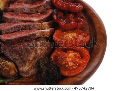 fresh grilled bbq beef meat rib eye steak on wooden plate with baked tomatoes mushroom, potatoes, hot chili pepper isolated on white backgrodun empty space for text