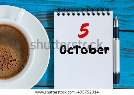 October 5th. Day 5 of month, tea or coffee cup with calendar on freelancer workplace background. Autumn time