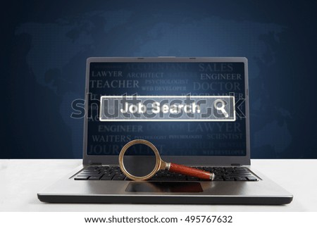 Picture of a laptop computer with a job search text on the screen and a magnifier on the keyboard