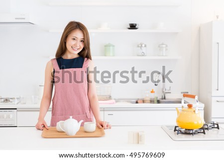 young attractive asian woman who gets ready to drink tea