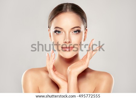 Beautiful Young Woman with Clean Fresh Skin  touch own face . Facial  treatment   . Cosmetology , beauty  and spa . Royalty-Free Stock Photo #495772555