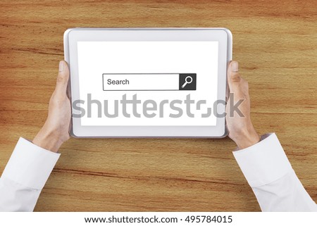 Close up of businessman hand holding a digital tablet with search box on the screen