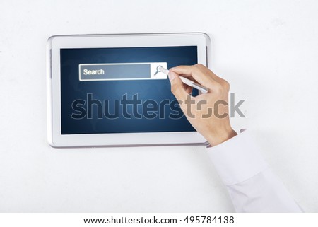 Businessman hand using a stylus pen to press a search bar on the digital tablet screen