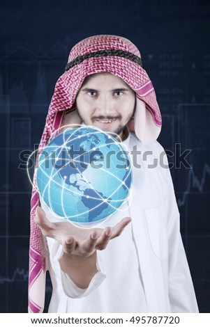 Arabian businessman holding a glove with business network connection icon. Elements of this image furnished by NASA