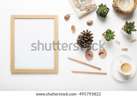 Flat lay of blank wooden picture frame with a collection of modern interior decor objects