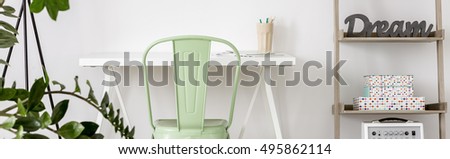 Home office area with minimalistic desk and chair in mint colour