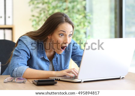 Amazed entrepreneur working on line with a laptop at office Royalty-Free Stock Photo #495894817