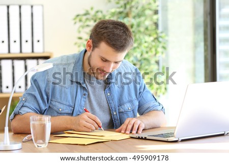 Entrepreneur writing address in a padded envelope before to send it 