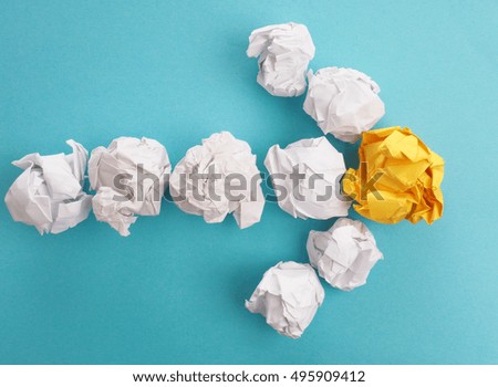 An arrow of crumpled paper on a blue background