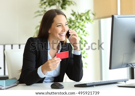 Happy businesswoman working buying on line with credit card and calling customer service at office Royalty-Free Stock Photo #495921739