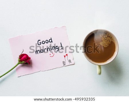 Good morning wording in note paper with red rose flowers, coffee mug  on white table from above, breakfast valentine's day