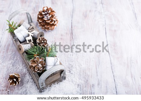 Christmas background with wooden box with pinecone, gifts and decoration on snow. Christmas greeting card with copy space.