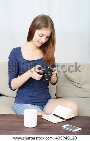 Woman reporter in office looking at photo camera