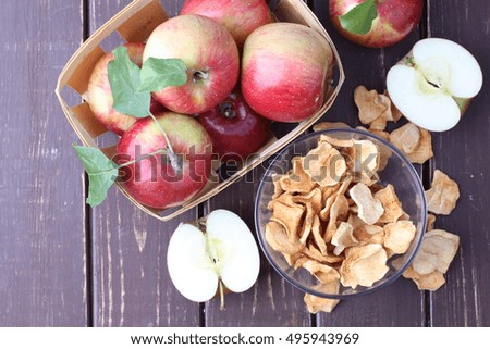 Ripe red apples on brown wooden background with dry apple.
