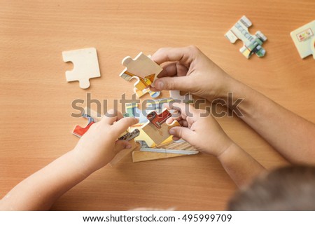 putting a puzzle together Royalty-Free Stock Photo #495999709